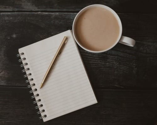 Benefits of Gratitude Practices - image of a notebook with a cup of coffee