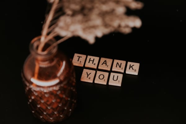 Benefits of Gratitude Practices - image of scrabble letters spelling out thank you with a vase and some dried flowers