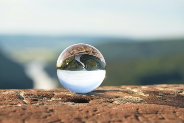 Toxic Positivity - image of a glass ball on a ledge looking over a scenic background